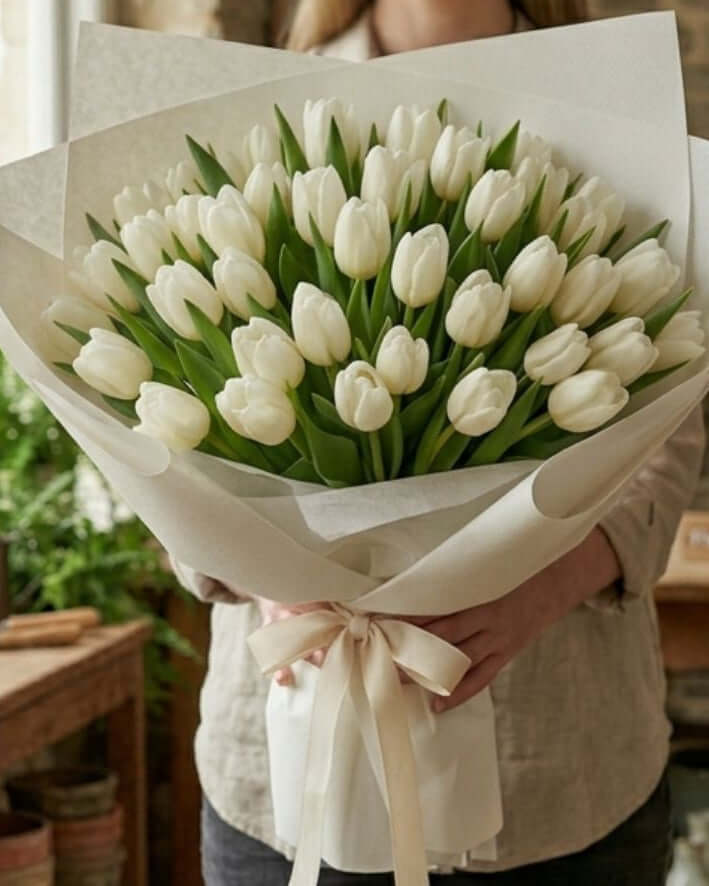 White Tulip Bouquet featuring 50 fresh white tulips elegantly arranged and wrapped in white paper.
